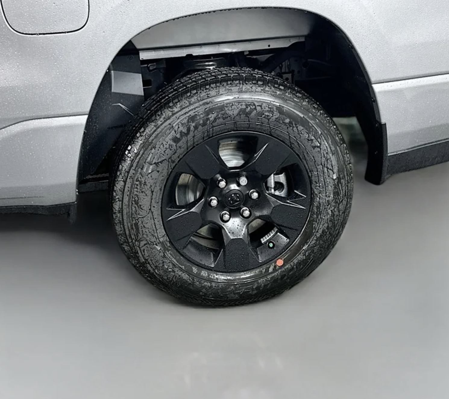 Close-up of a 275/65R18 black sidewall all-season tire on a 2025 RAM 1500 in silver